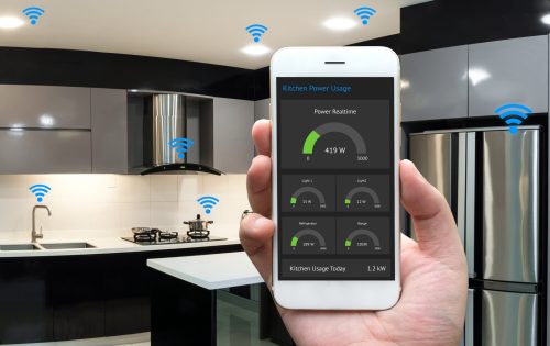 Internet of things , iot , smart home , kitchen , network connect concept. Human hand holding white phone, smart home application to count power usage application and wifi icon with kitchen background